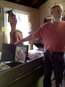 Peter telling the story of Hardy General Store with a picture of the store owner next to the sculpted one.