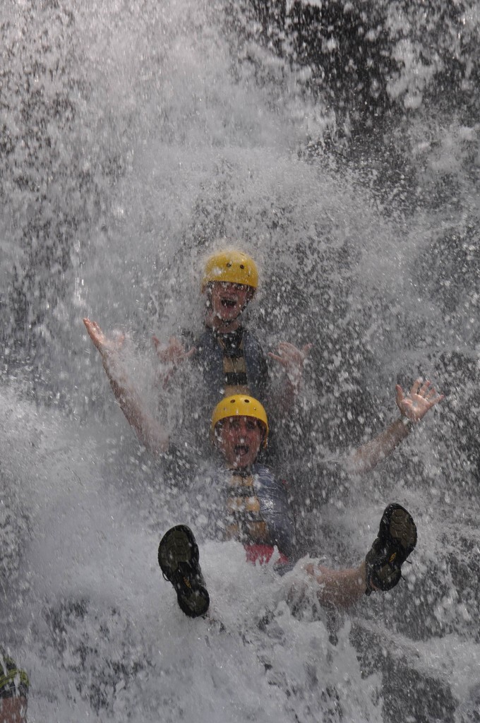 Kyle and Morgan submerged in the waterfall